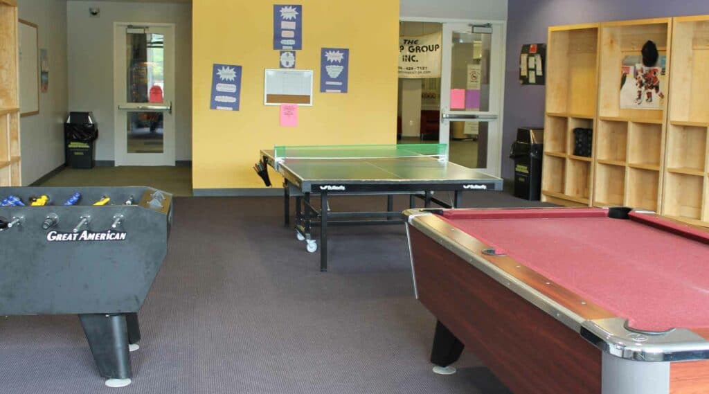 two pool tables and a ping pong table are centered in a game room at the HYCC